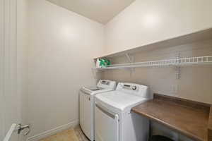 Laundry room featuring washer and clothes dryer and light tile patterned floors