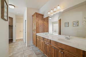 Bathroom with double vanity and light tile patterned floors