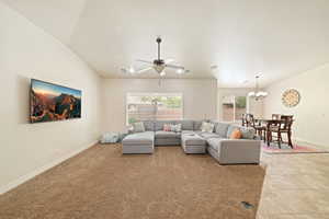 Living area with ceiling fan, vaulted ceiling, and hanging lights