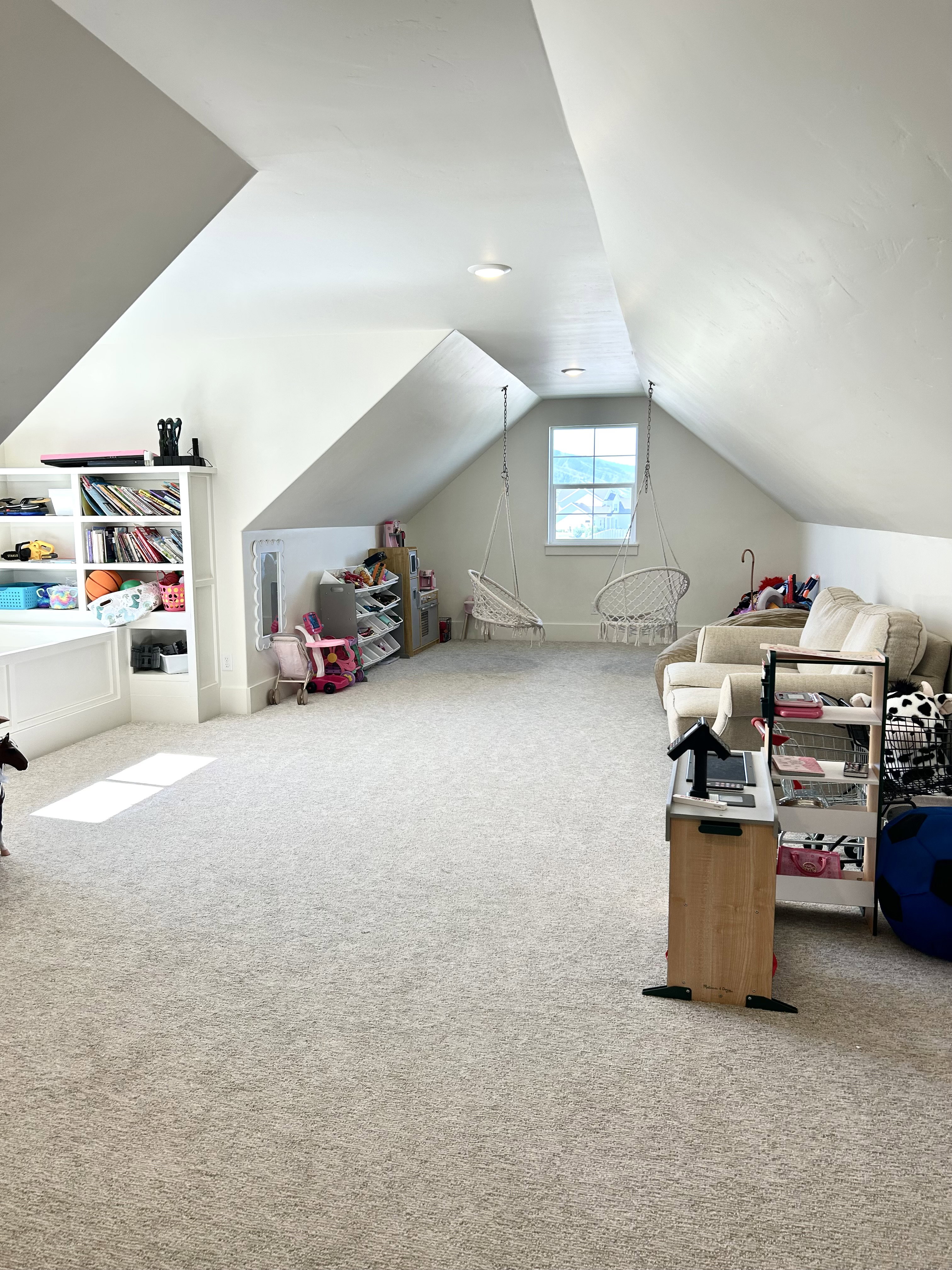Spacious bonus room featuring vaulted ceilings, recessed lighting, neutral carpeting, and a built-in shelving unit