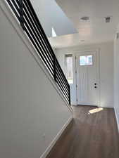 Entrance foyer with dark wood finished floors and a textured ceiling