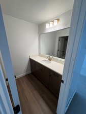 Bathroom featuring vanity, a textured ceiling, and dark wood-style floors
