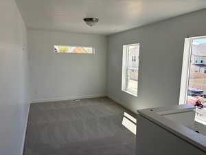 Unfurnished room featuring dark carpet and a textured ceiling