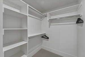 Walk in closet featuring light carpet