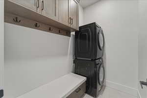 Laundry room featuring stacked washer / dryer and cabinet space