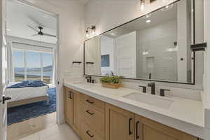 Bathroom featuring double vanity, a water and mountain view, ensuite bathroom, a shower stall, and recessed lighting