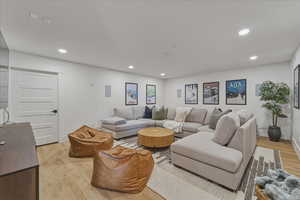 Living room with light wood-style floors and recessed lighting