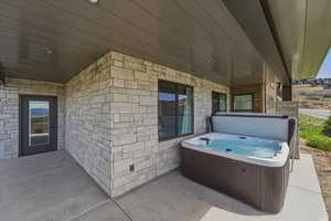 View of patio with a hot tub
