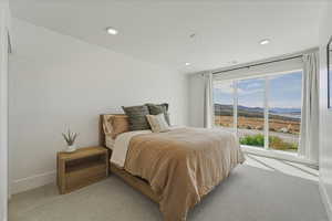 Bedroom with a mountain view, light colored carpet, and recessed lighting