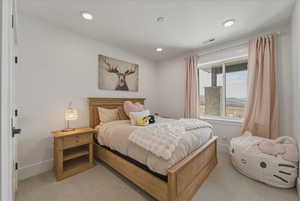 Bedroom with light colored carpet and recessed lighting