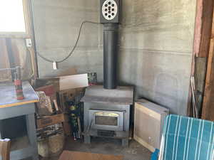 Detailed view of unfinished concrete floors and a wood stove