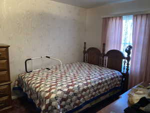 Bedroom featuring wallpapered walls