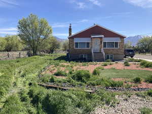 View of front facade with brick siding, a mountain view, a chimney, and entry steps