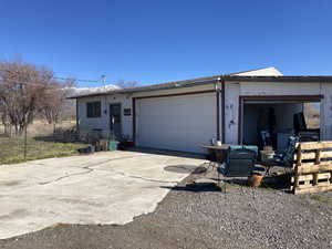 View of front of house featuring concrete driveway, an attached garage, and stucco siding