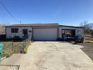 Single story home featuring a garage, stucco siding, concrete driveway, and roof with shingles