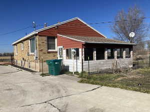 View of side of property featuring a sunroom and a shingled roof