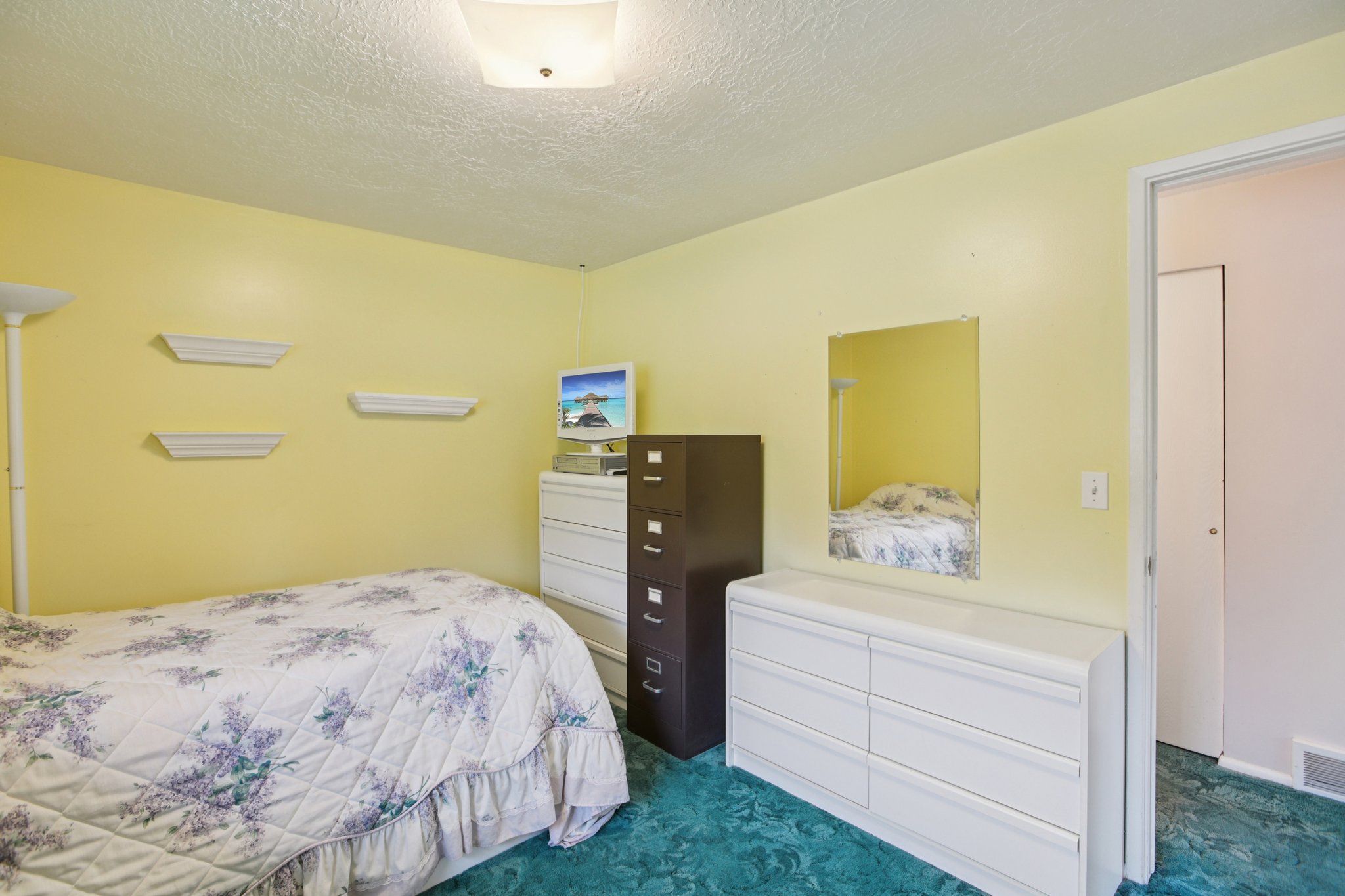 Bedroom featuring a textured ceiling and dark colored carpet