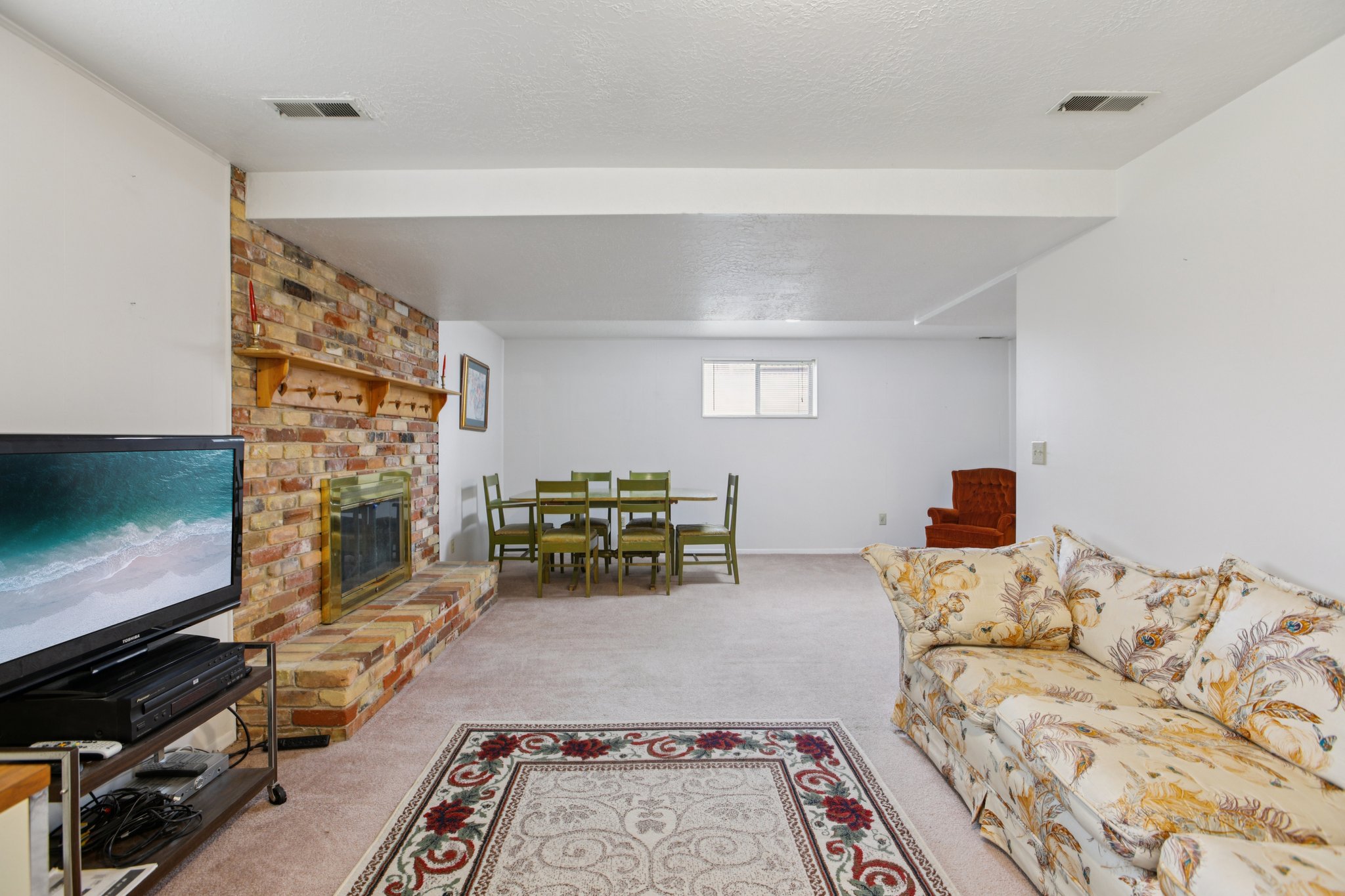 Living room featuring light colored carpet, a fireplace, and a textured ceiling