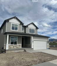 Craftsman house with stone siding, covered porch, concrete driveway, and a mountain view