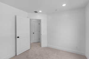 Spare room featuring light carpet and recessed lighting