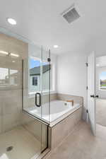 Full bath featuring a shower stall, a bath, and light tile patterned floors