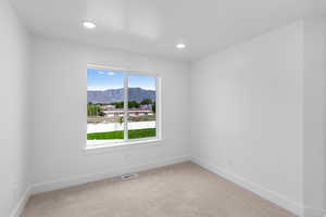 Spare room with light colored carpet, a mountain view, and recessed lighting