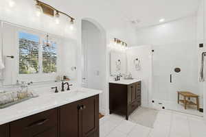 Master bath with two vanities, walk in shower, jetted tub, and marble finishes
