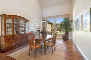 Dining area featuring dark wood-style flooring and lofted ceiling