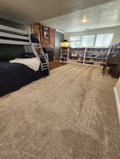 Carpeted bedroom featuring a fireplace and a textured ceiling