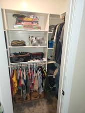 Walk in closet featuring dark carpet