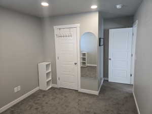 Neutral gray wall tones, recessed ceiling lighting, and gray carpeting