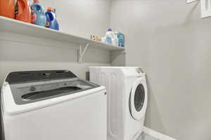Laundry room featuring washing machine and dryer and baseboards