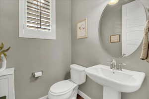 Half bathroom with toilet and baseboards