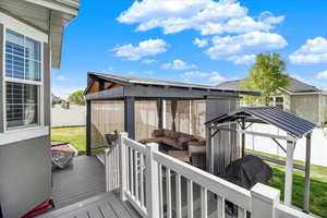 Wooden deck featuring a gazebo, outdoor lounge area, a yard, and grilling area