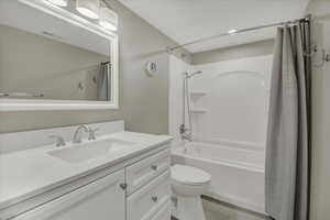 Bathroom with vanity, shower / bath combo, and light wood-style flooring