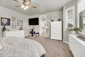 Bedroom with light carpet, ceiling fan, and ensuite bath