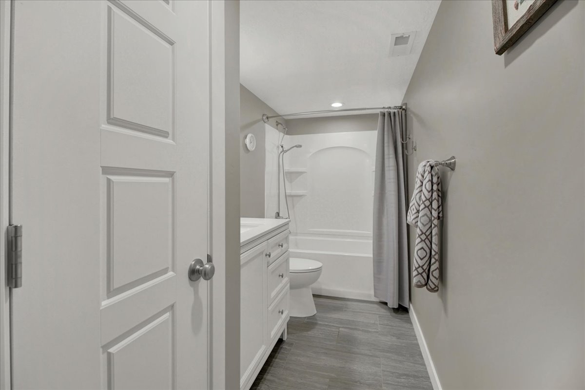 Full bathroom with vanity, shower / tub combo, and recessed lighting