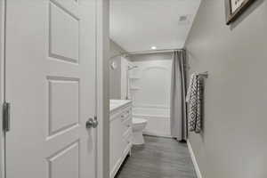 Full bathroom with vanity, shower / tub combo, and recessed lighting