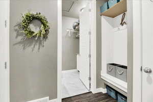 Mudroom featuring baseboards and dark marble finish flooring