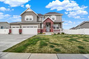 View of front facade with a gate, stucco siding, brick siding, an attached garage, and concrete driveway