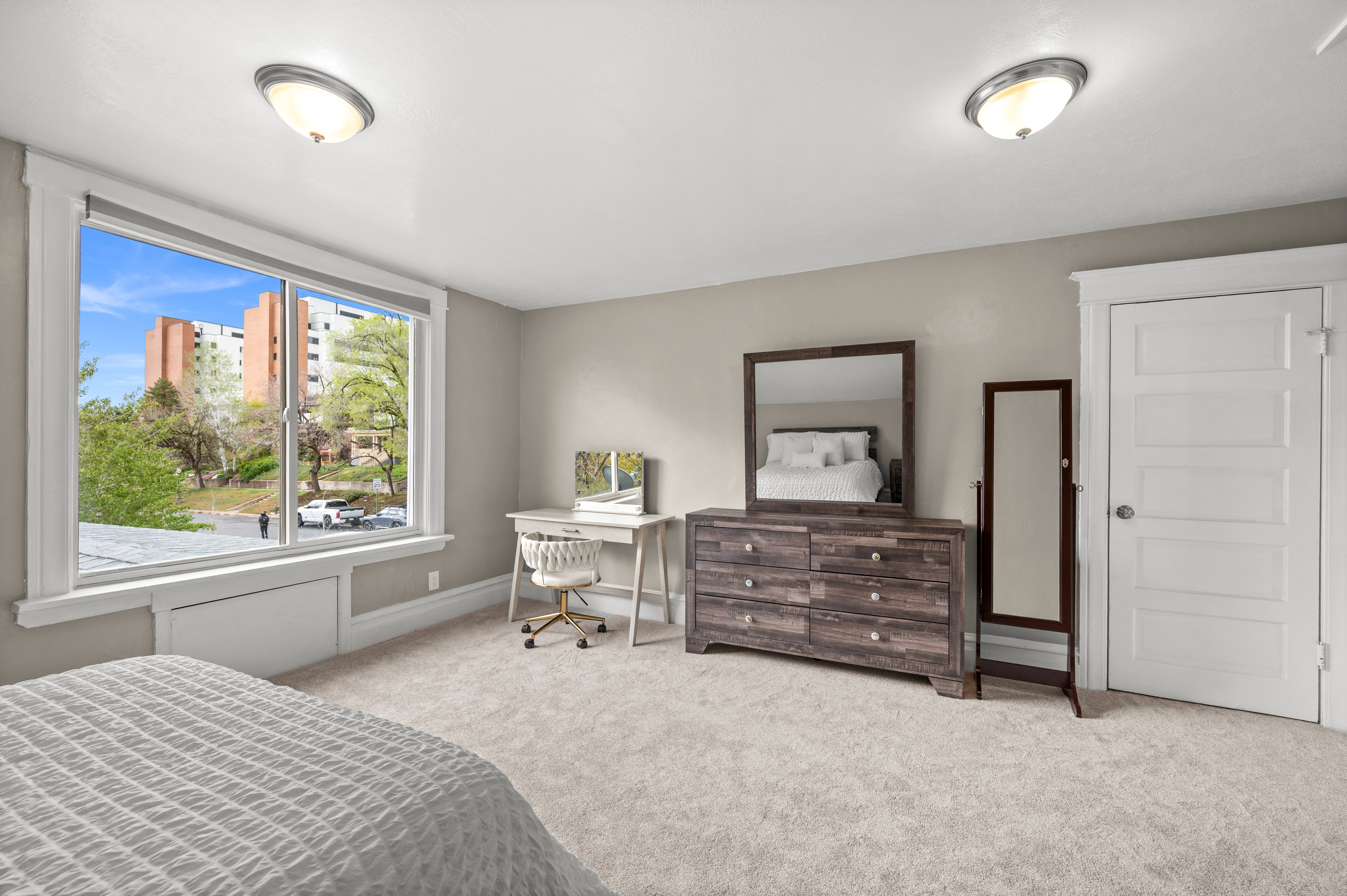 Bedroom with light colored carpet and baseboards