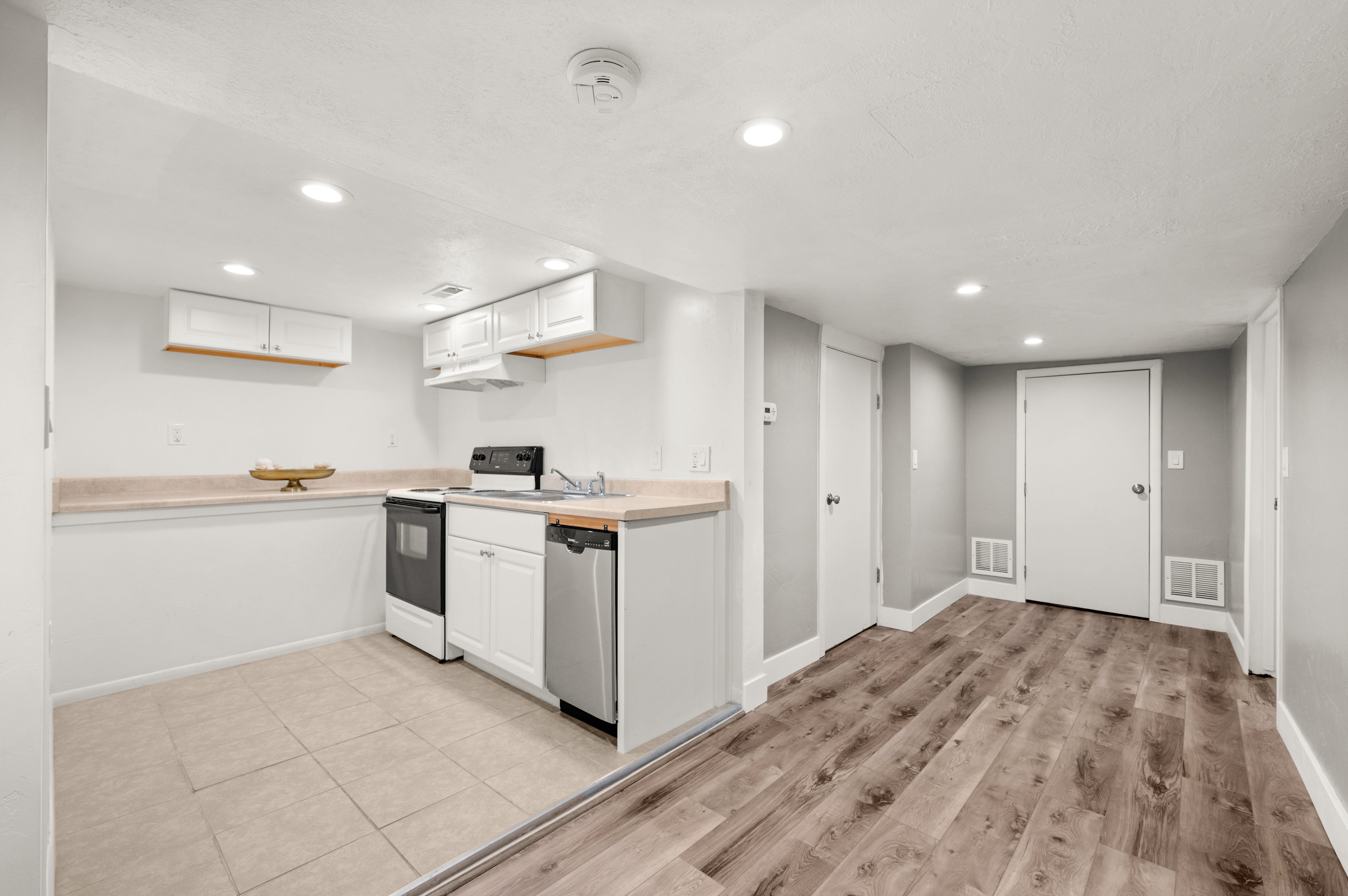 Kitchen featuring light countertops, white range with electric stovetop, white cabinetry, recessed lighting, and light wood-style flooring