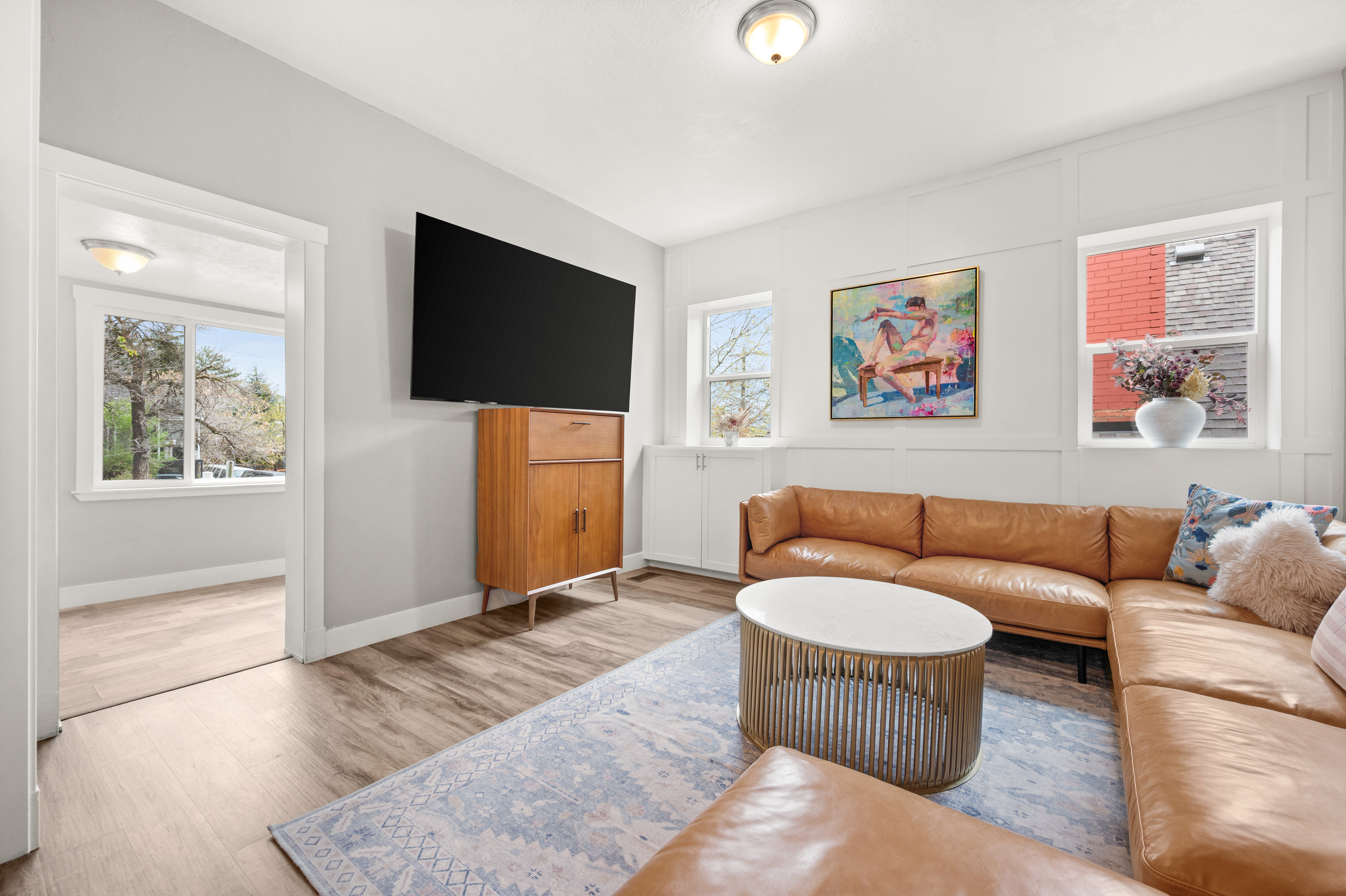 Living room featuring light wood-type flooring and a decorative wall
