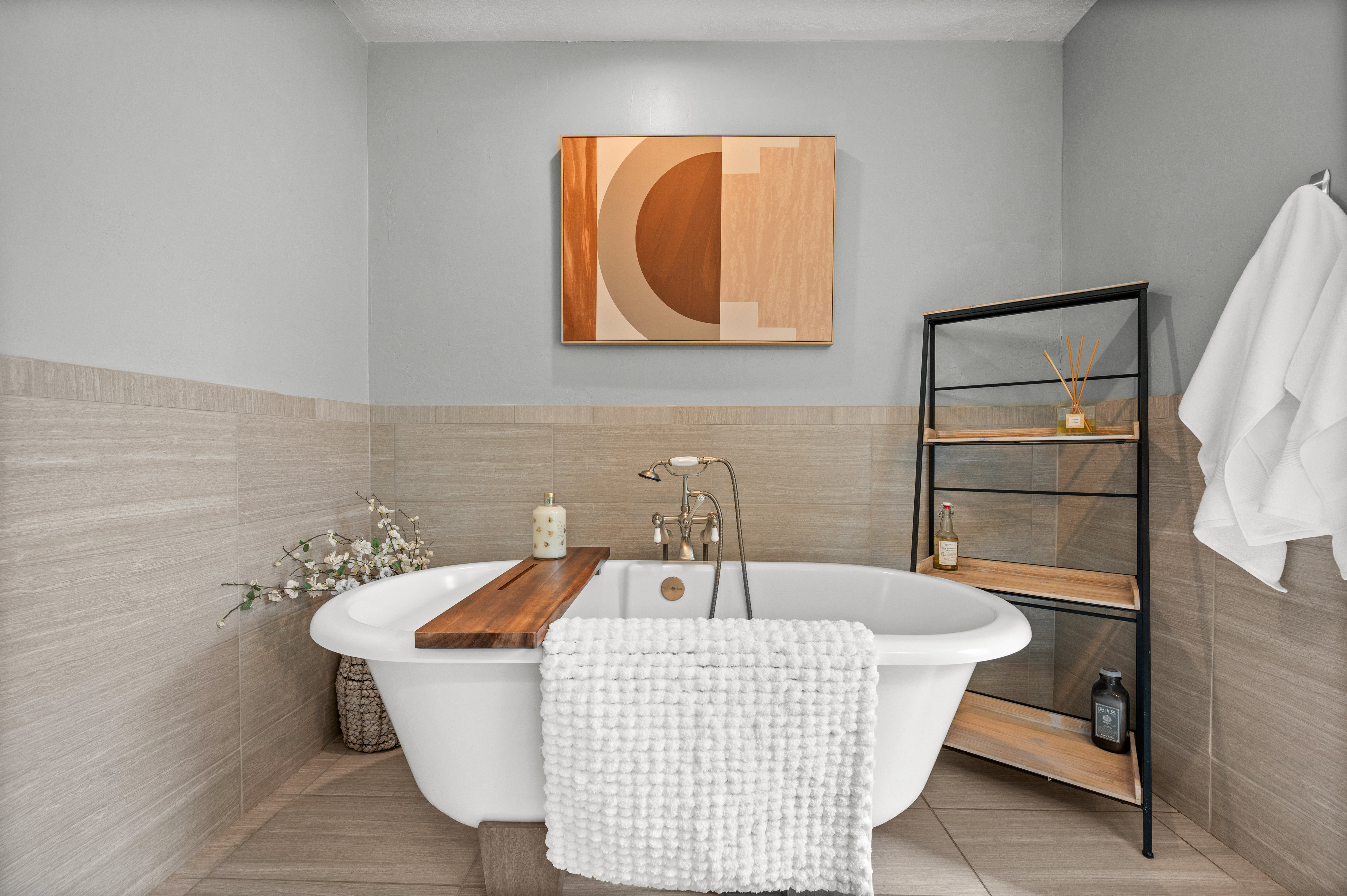 Bathroom featuring tile walls, a freestanding tub, tile patterned floors, and wainscoting