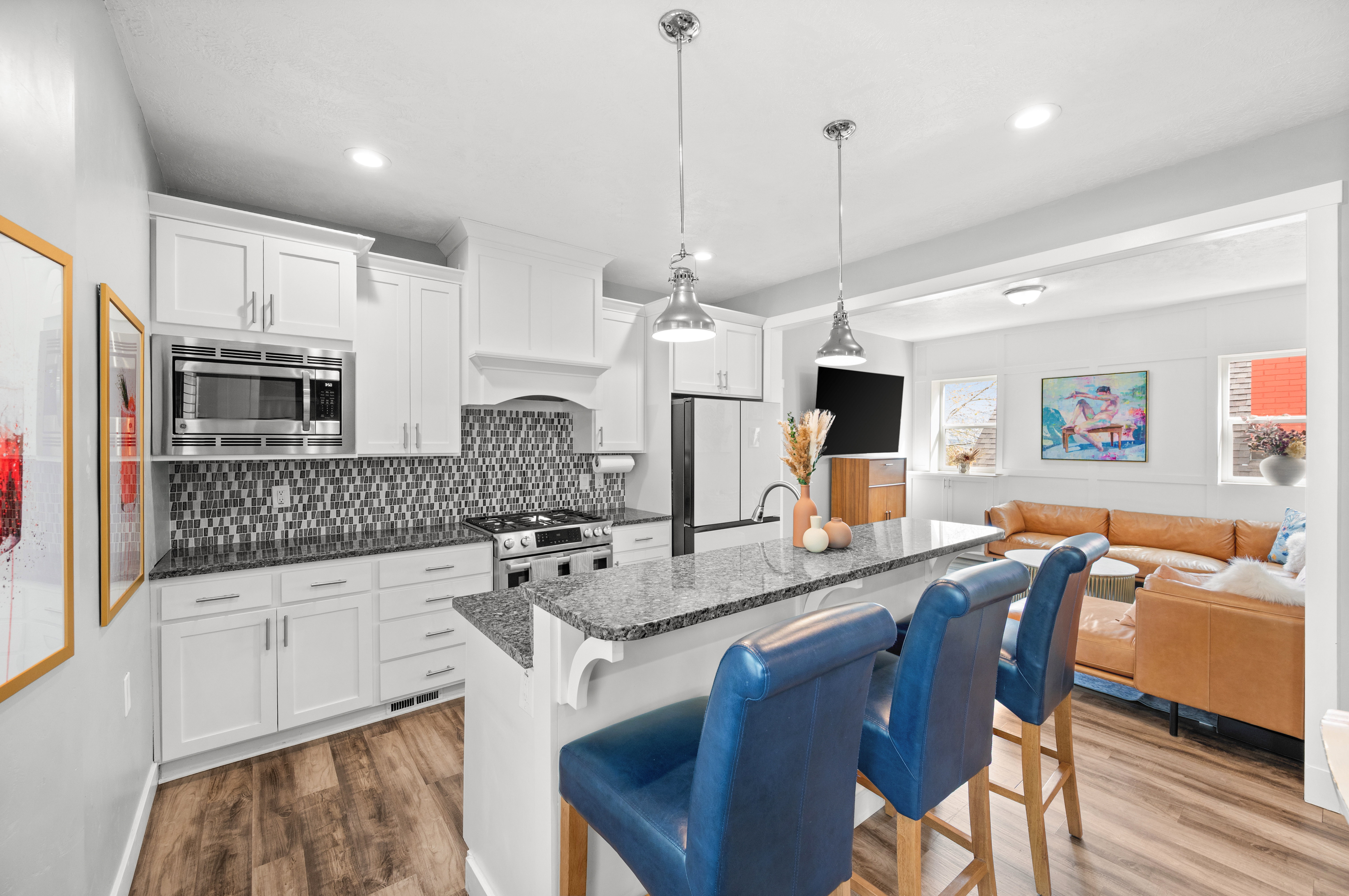 Kitchen with white cabinetry, light wood-style flooring, open floor plan, and a breakfast bar