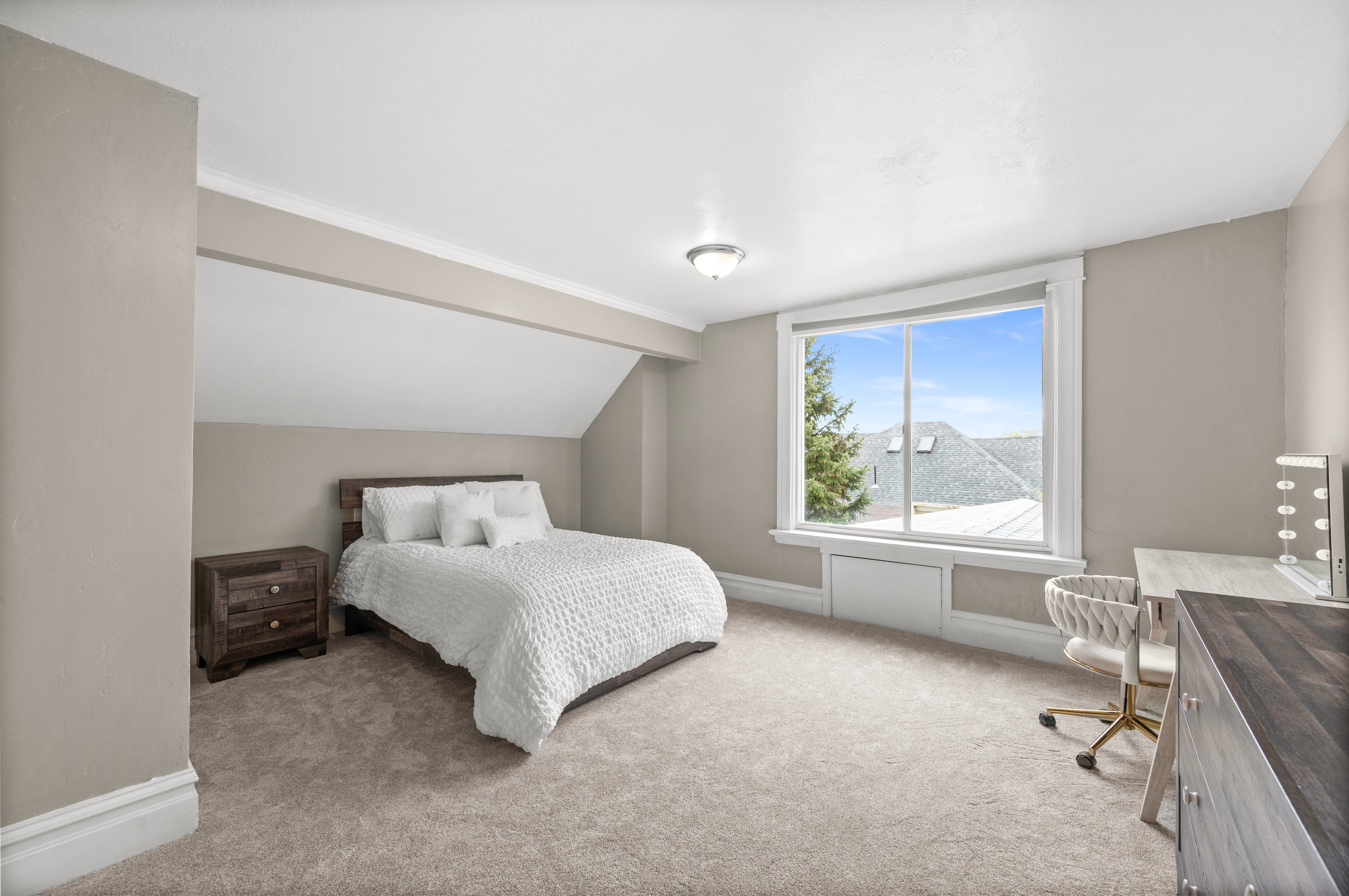 Bedroom with carpet flooring, vaulted ceiling, and a desk