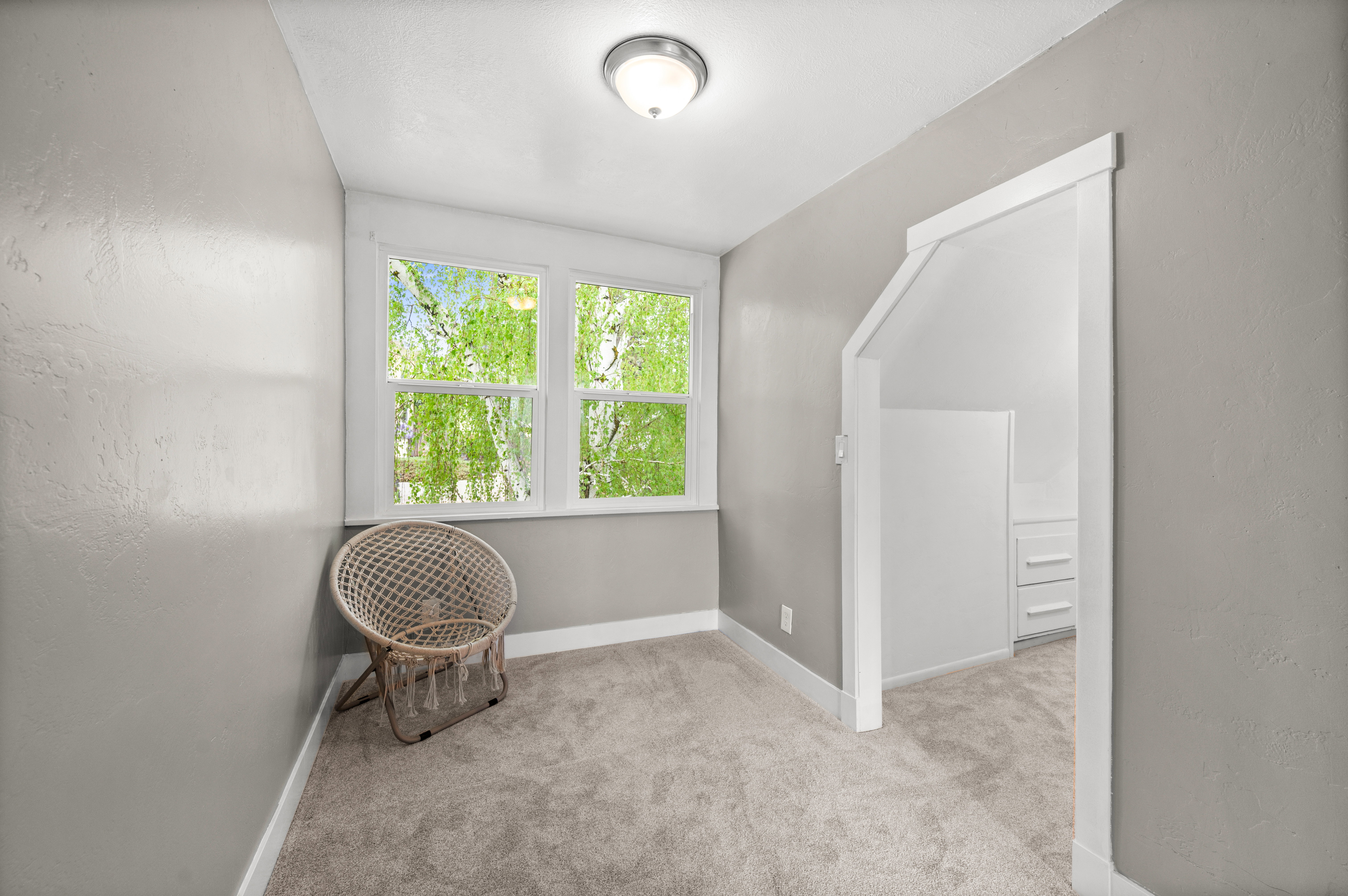 Sitting room with light colored carpet and a textured wall