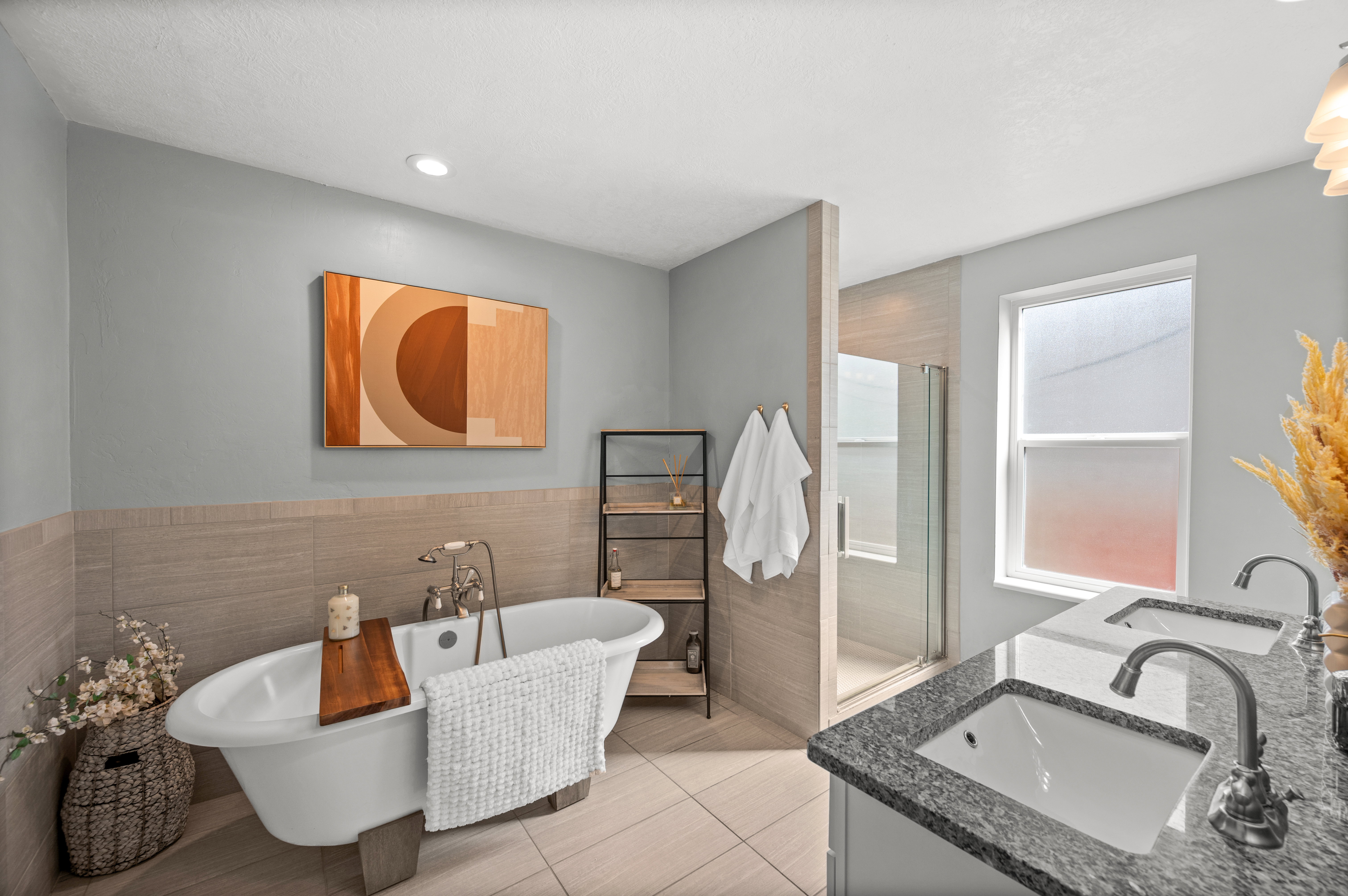Full bath featuring a stall shower, a freestanding bath, double vanity, tile walls, and light tile patterned floors