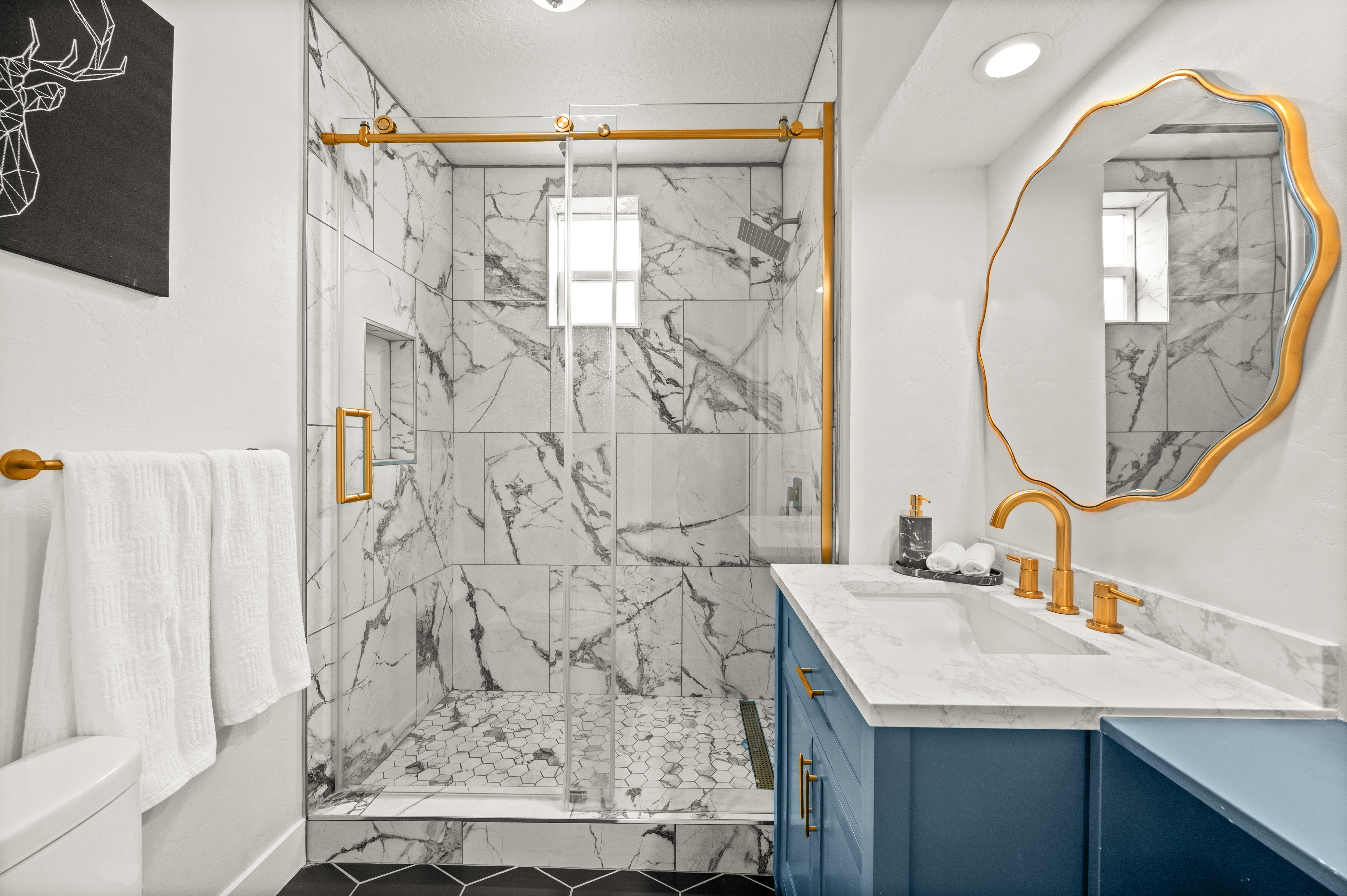 Full bathroom featuring vanity, healthy amount of natural light, and a marble finish shower