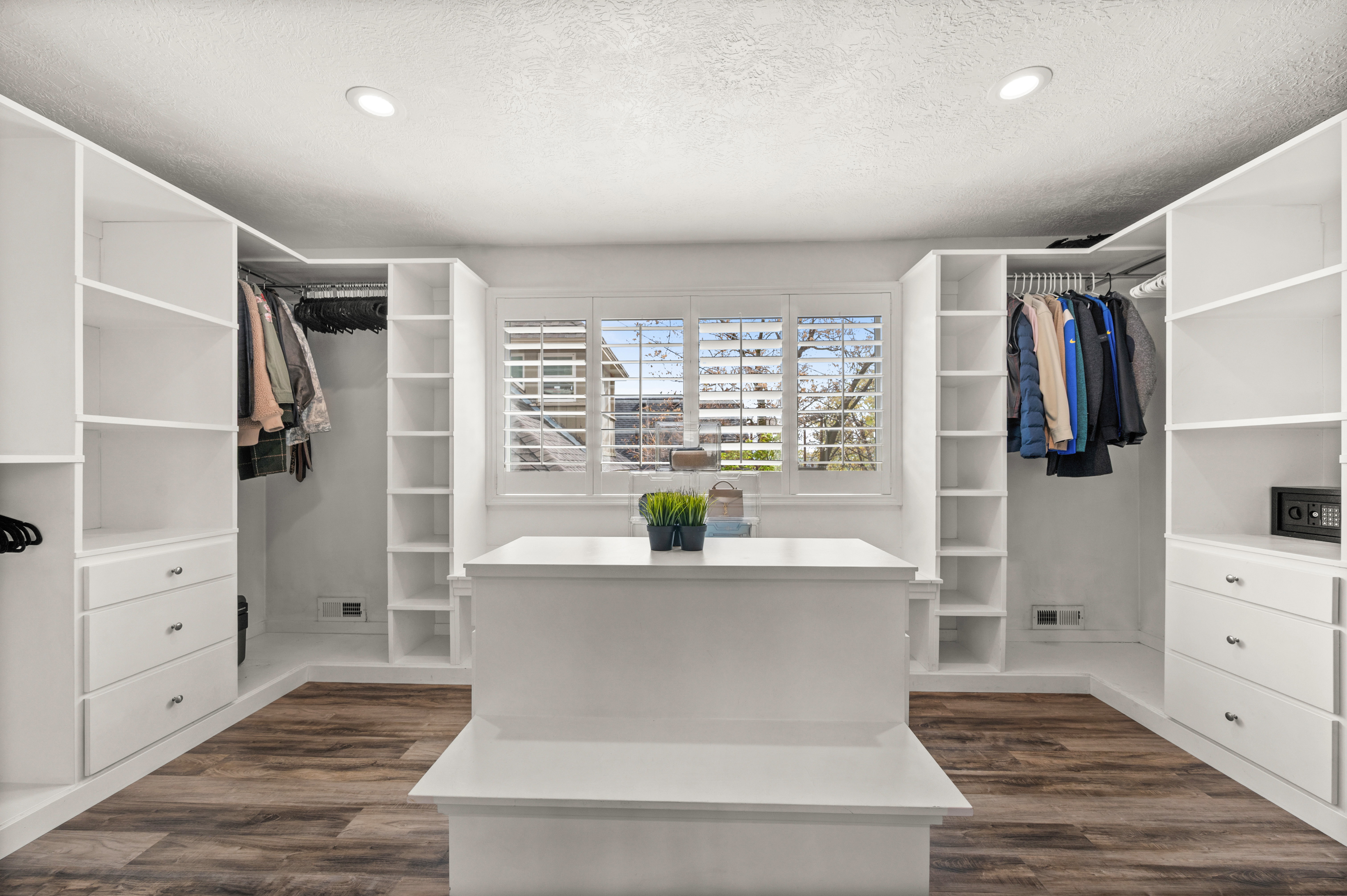 Walk in closet with dark wood-style flooring